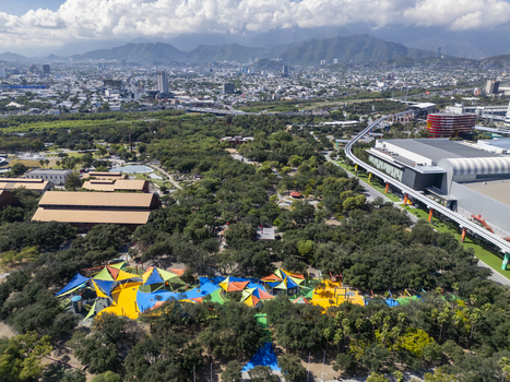 Aerial view of Fundidora Park and Paseo de la Mujer Park featuring colorful playground structures surrounded by lush trees and urban infrastructure in Monterrey Nuevo Leon Mexico. Aerial view of Fundidora Park and Paseo de la Mujer Park featuring colorful playground structures surrounded by lush trees and urban infrastructure in Monterrey Nuevo Leon Mexico.