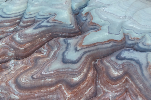 Aerial view of the undulating layered formations of candy colored rock revealing nature s artistry in contrasting hues and textures Hanksville Utah United States. Aerial view of the undulating layered formations of candy colored rock revealing nature s artistry in contrasting hues and textures Hanksville Utah United States.