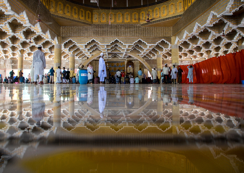 Tangail Bangladesh 21 March 2021 View of the grand mosque s interior its golden reflective floor mirroring intricate geometric walls as worshippers gather. Tangail Bangladesh 21 March 2021 View of the grand mosque s interior its golden reflective floor mirroring intricate geometric walls as worshippers gather.