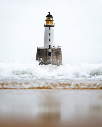 View of a dramatic lighthouse amidst crashing waves and a stormy sea Crimond Fraserburgh Great Britain.