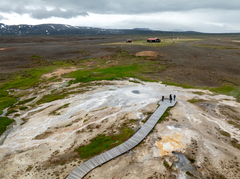 Aerial view of Hveravellir geothermal area with a wooden boardwalk steaming hot springs and visitors in the highlands of Hunabyggd Iceland.
