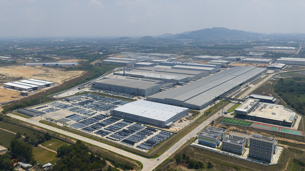 Aerial view of the BYD Thailand Rayong Office Building and vast industrial manufacturing complex with rows of parked vehicles and distant hills in Rayong Thailand. Aerial view of the BYD Thailand Rayong Office Building and vast industrial manufacturing complex with rows of parked vehicles and distant hills in Rayong Thailand.
