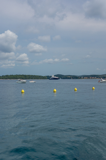 View of boats and yellow buoys floating on the calm Adriatic Sea near the coast of Rovinj Istria County Croatia. View of boats and yellow buoys floating on the calm Adriatic Sea near the coast of Rovinj Istria County Croatia.