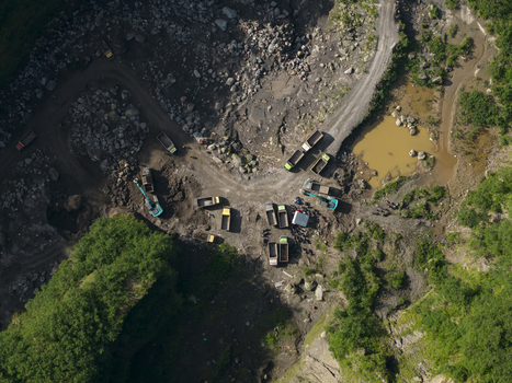 Aerial view of Tambang Pasir Merapi Kali Gendol Sand Mine with excavators and dump trucks operating on the rocky terrain Kecamatan Cangkringan Daerah Istimewa Yogya Indonesia. Aerial view of Tambang Pasir Merapi Kali Gendol Sand Mine with excavators and dump trucks operating on the rocky terrain Kecamatan Cangkringan Daerah Istimewa Yogya Indonesia.