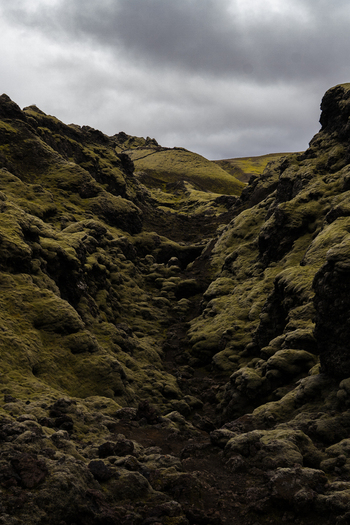View of moss covered crags and rugged terrain carve a path beneath a brooding sky in Skaftárhreppur Skaftárhreppur Iceland. View of moss covered crags and rugged terrain carve a path beneath a brooding sky in Skaftárhreppur Skaftárhreppur Iceland.