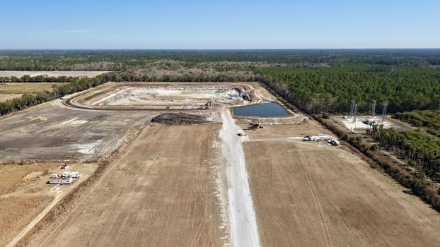 Aerial view of construction site with contrasting textures of bare earth and lush greenery reflecting the clear blue sky Elkton Florida United States. Aerial view of construction site with contrasting textures of bare earth and lush greenery reflecting the clear blue sky Elkton Florida United States.