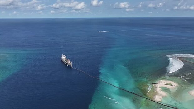 Aerial view of an industrial ship in the turquoise sea Maldives.