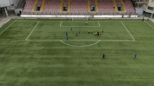 Aerial view of a football match in progress at a stadium in Lagos Island featuring players on the green pitch empty spectator seating and clear markings on the field in Lagos Lagos Nigeria. Aerial view of a football match in progress at a stadium in Lagos Island featuring players on the green pitch empty spectator seating and clear markings on the field in Lagos Lagos Nigeria.