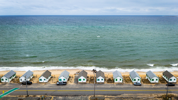 Aerial view of the iconic Days Cottages lined up along the sandy beach and the Atlantic Ocean in Truro Cape Cod Massachusetts United States.