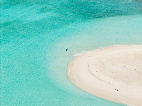 Aerial view of a pristine sandbar embraced by turquoise waters a serene haven under the sun Vashafaru Island Thiladhummathi Atoll Maldives.