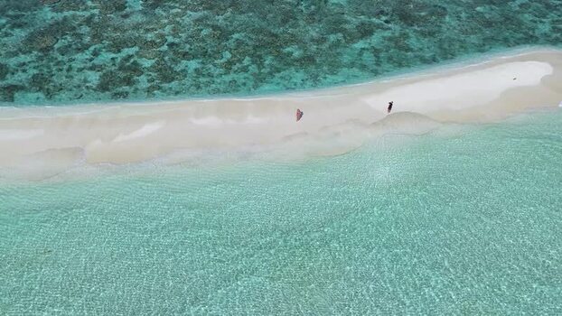 Aerial view of people walking on a white sandbar Maldives. Aerial view of people walking on a white sandbar Maldives.