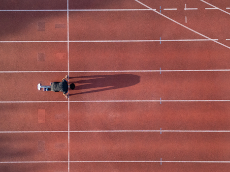 Aerial view of a runner in starting blocks on a red running track with white lane markings in Almere Flevoland Netherlands.