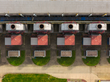 Aerial view of industrial facility with large exhaust chimneys and red roofs surrounded by green lawns Hrusky South Moravian Region Czechia. Aerial view of industrial facility with large exhaust chimneys and red roofs surrounded by green lawns Hrusky South Moravian Region Czechia.