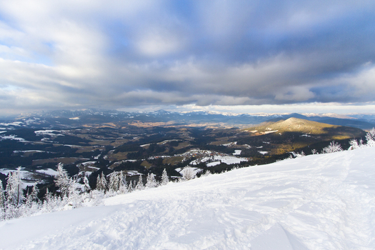 View of snow covered landscape under a dramatic sky with contrasting light and shadows creating depth and texture Schöckl Styria Austria. View of snow covered landscape under a dramatic sky with contrasting light and shadows creating depth and texture Schöckl Styria Austria.