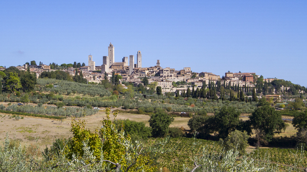 View of the medieval skyline punctuated by towers rising from the rolling green hills under a clear blue sky San Gimignano Tuscany Italy. View of the medieval skyline punctuated by towers rising from the rolling green hills under a clear blue sky San Gimignano Tuscany Italy.