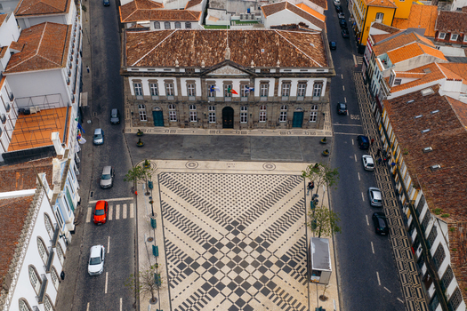 Aerial view of the historic town hall and the patterned cobblestone square of Praca Velha surrounded by traditional buildings in Angra do Heroismo Azores Portugal.