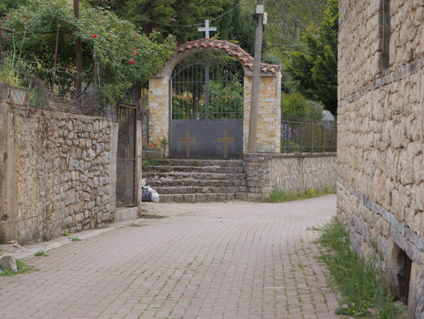 View of the stone entrance gate with crosses leading to a church in the village of Lin Korce County Albania.