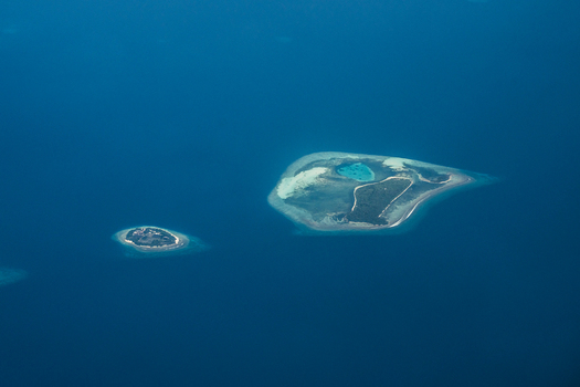 Aerial view of islands surrounded by the vast deep blue ocean where the turquoise shallows meet the sandy shores Flight from Male to Hanimaadhoo island Maldives.