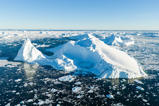 Aerial view of the Ilulissat glacier with massive icebergs floating in the dark blue waters of the Arctic Ocean Greenland. Aerial view of the Ilulissat glacier with massive icebergs floating in the dark blue waters of the Arctic Ocean Greenland.