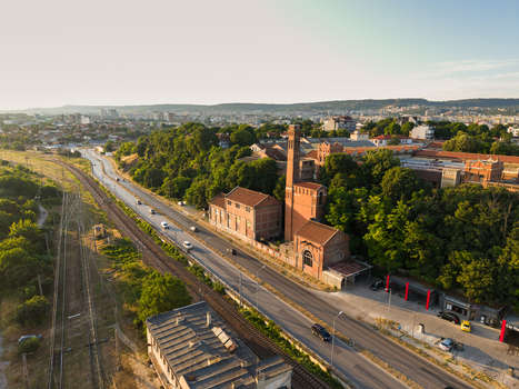 Aerial view of the historic Varna Thermal Power Plant with its iconic brick chimney situated beside a road and railway tracks in Varna Varna Bulgaria. Aerial view of the historic Varna Thermal Power Plant with its iconic brick chimney situated beside a road and railway tracks in Varna Varna Bulgaria.
