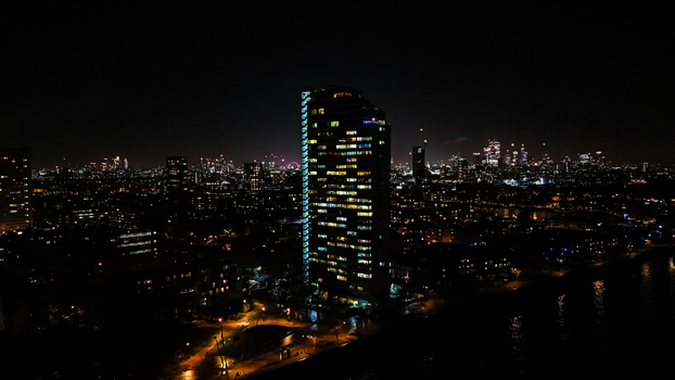 Aerial view of the illuminated London skyline at night with glowing skyscrapers and city lights stretching across the urban landscape in London England United Kingdom. Aerial view of the illuminated London skyline at night with glowing skyscrapers and city lights stretching across the urban landscape in London England United Kingdom.