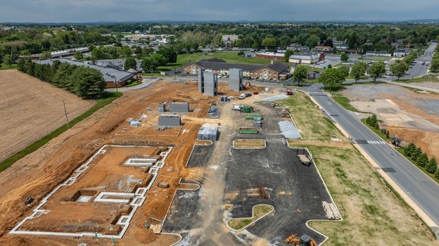 Aerial view of a construction site with concrete foundations and building frames surrounded by fields and roads in Ronks Pennsylvania United States. Aerial view of a construction site with concrete foundations and building frames surrounded by fields and roads in Ronks Pennsylvania United States.