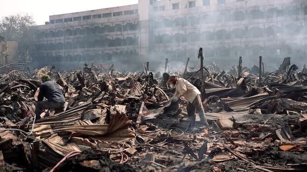 View of workers searching through fire debris in Dhaka Bangladesh. View of workers searching through fire debris in Dhaka Bangladesh.