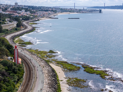 Aerial view of Passeio Maritimo de Alges with the coastal railway and people walking along the waterfront in Cruz Quebrada Lisboa Portugal. Aerial view of Passeio Maritimo de Alges with the coastal railway and people walking along the waterfront in Cruz Quebrada Lisboa Portugal.