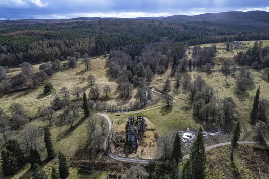 Aerial view of the ruins of Guisachan Historic House set within a landscape of trees and rolling fields in Beauly Glen Affric Scotland United Kingdom. Aerial view of the ruins of Guisachan Historic House set within a landscape of trees and rolling fields in Beauly Glen Affric Scotland United Kingdom.
