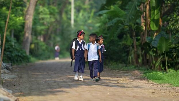 View of school children walking on a rural road in Bogura Bangladesh.
