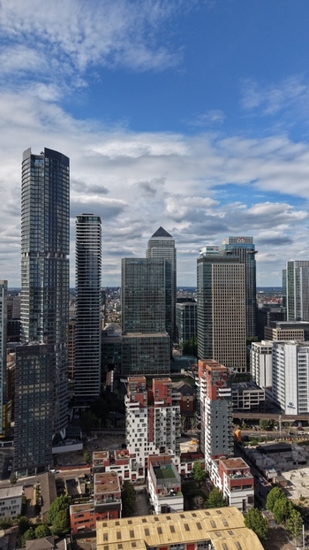 London United Kingdom 16 June 2026 Aerial view of Canary Wharf skyline featuring modern skyscrapers and residential towers under a cloudy sky.