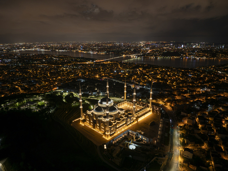 Aerial view of Grand Camlica Mosque illuminated at night featuring its grand dome and minarets overlooking the sprawling city lights in Uskudar Istanbul Turkiye. Aerial view of Grand Camlica Mosque illuminated at night featuring its grand dome and minarets overlooking the sprawling city lights in Uskudar Istanbul Turkiye.