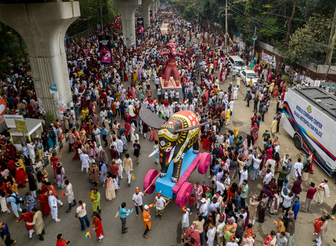 Dhaka Bangladesh 13 April 2026 Aerial view of a vibrant procession with colorful floats and a massive crowd under elevated concrete structures.