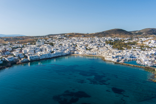 Greece 21 September 2026 Aerial view of a coastal town with white washed buildings a small harbor with boats and turquoise waters under a clear blue sky. Greece 21 September 2026 Aerial view of a coastal town with white washed buildings a small harbor with boats and turquoise waters under a clear blue sky.