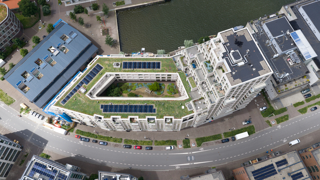 Aerial view of a modern residential building with a green roof and solar panels featuring an inner courtyard and located along the Cruquiusweg in Amsterdam Noord Holland Netherlands.