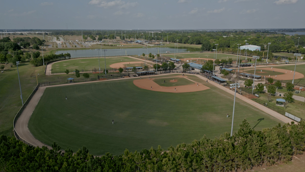 Aerial view of the baseball field complex featuring multiple diamonds manicured grass dirt infields and surrounding trees in Polk City Florida United States. Aerial view of the baseball field complex featuring multiple diamonds manicured grass dirt infields and surrounding trees in Polk City Florida United States.