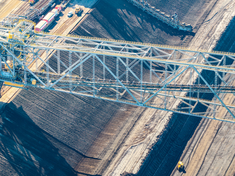 Aerial view of the Tagebau Welzow Sud brown coal open pit mine featuring a massive bucket wheel excavator operating within the deep excavation site in Spremberg Brandenburg Germany. Aerial view of the Tagebau Welzow Sud brown coal open pit mine featuring a massive bucket wheel excavator operating within the deep excavation site in Spremberg Brandenburg Germany.
