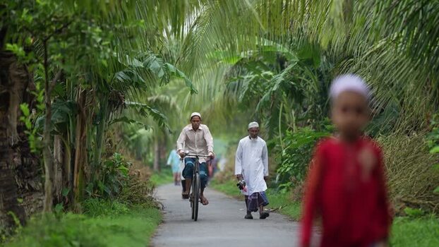 View of a man riding a bicycle on a rural path Bangladesh. View of a man riding a bicycle on a rural path Bangladesh.