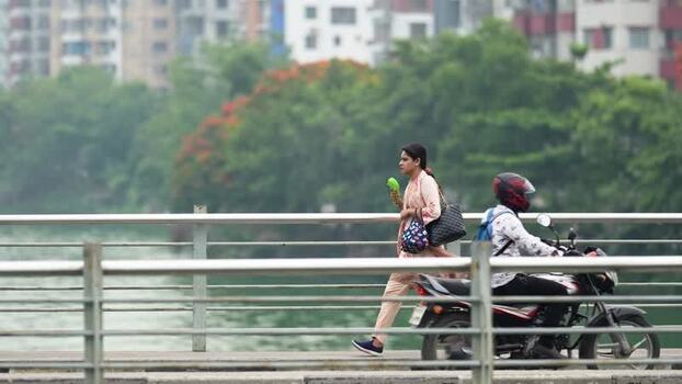 View of a woman walking on a bridge in Dhaka Bangladesh.