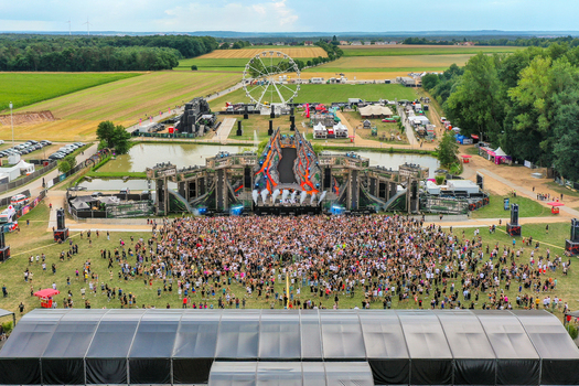 Herzogenaurach Germany 24 July 2025 Aerial view of the Open Beatz Festival featuring a massive main stage a large crowd of people and a Ferris wheel in the background.