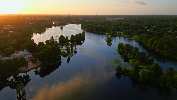 Aerial view of a river winding through a lush green neighborhood at sunset with dense trees and calm water in Tampa Florida United States. Aerial view of a river winding through a lush green neighborhood at sunset with dense trees and calm water in Tampa Florida United States.