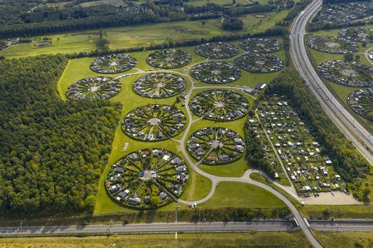 Aerial view of the unique circular allotment gardens of Haveforeningen Harekaer with green hedges and small houses near a forest and highway in Brondby Denmark. Aerial view of the unique circular allotment gardens of Haveforeningen Harekaer with green hedges and small houses near a forest and highway in Brondby Denmark.