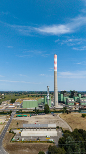 Aerial view of the TTEP Tavazzano thermal power plant featuring a tall chimney and industrial buildings set amidst rural landscape in Tavazzano con Villavesco Lombardy Italy.