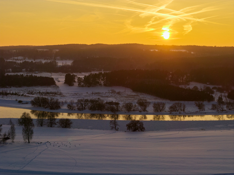 Aerial view of the snow covered archaeological site of Kernave and the winding Neris river under a golden sunset sky Kernave Vilnius County Lithuania.