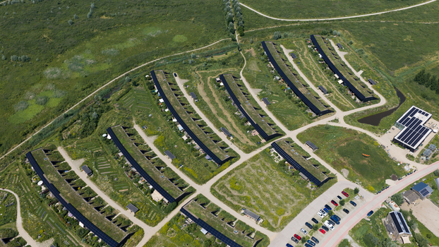 Aerial view of sustainable housing development with green roofs and solar panels integrated into the landscape in Almere Flevoland Netherlands. Aerial view of sustainable housing development with green roofs and solar panels integrated into the landscape in Almere Flevoland Netherlands.