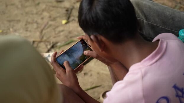 View of a young boy playing a mobile game on a smartphone Bangladesh. View of a young boy playing a mobile game on a smartphone Bangladesh.