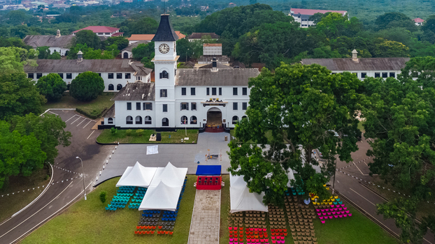 Aerial view of Achimota School featuring its iconic clock tower white colonial buildings lush trees and rows of chairs set up for an event in Achimota Greater Accra Region Ghana. Aerial view of Achimota School featuring its iconic clock tower white colonial buildings lush trees and rows of chairs set up for an event in Achimota Greater Accra Region Ghana.