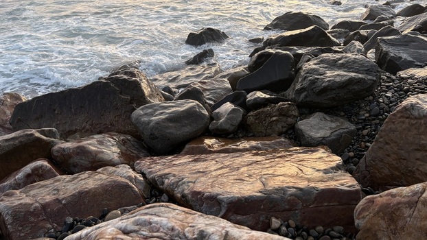 View of large coastal boulders and rocks with ocean waves crashing against the shore during sunset Oceanside California United States. View of large coastal boulders and rocks with ocean waves crashing against the shore during sunset Oceanside California United States.