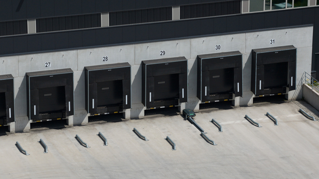 Aerial view of industrial warehouse loading docks with numbered bays and concrete yard in Hattemerbroek Gelderland Netherlands.