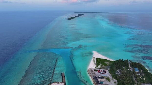 Aerial view of tropical island and turquoise lagoon in Maldives.